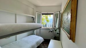 a bedroom with two bunk beds and a window at Postcard view 3 minutes walk from the lake in Menaggio