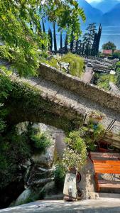 an old stone bridge with a bunch of plants at Postcard view 3 minutes walk from the lake in Menaggio