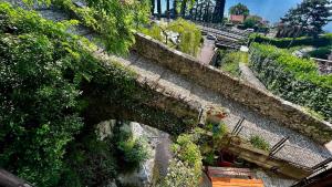 an old stone bridge with ivy growing on it at Postcard view 3 minutes walk from the lake in Menaggio