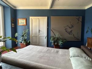 a bedroom with blue walls and a bed with plants at Postcard view 3 minutes walk from the lake in Menaggio