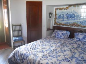 a bedroom with a bed with a painting on the wall at Windmill Hill in Cercal +27 photos