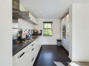 a kitchen with white cabinets and a black tile floor at Sleeps6- FamilyFriendly- FreeParking- 3Br in Stafford +25 photos
