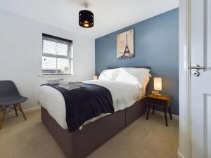 a bedroom with a bed with a blue wall at Sleeps6- FamilyFriendly- FreeParking- 3Br in Stafford
