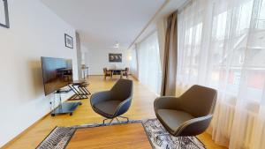 Una sala de estar con dos sillas y un televisor. en 2BR flat in the city center - West 12, en Zúrich