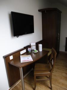 Zimmer mit einem Schreibtisch und einem TV an der Wand in der Unterkunft Wein-Träume in Thüngersheim