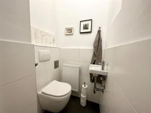 a white bathroom with a toilet and a sink at Panda Apartment in Vienna