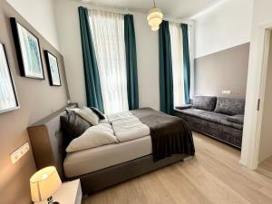 a bedroom with a bed and a couch in a room at Panda Apartment in Vienna