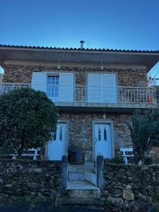 a stone house with a balcony on top of it at Casa Paraíso in Ribeira de Pena