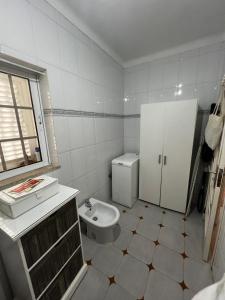 a white bathroom with a toilet and a sink at Casa Paraíso in Ribeira de Pena +7 photos