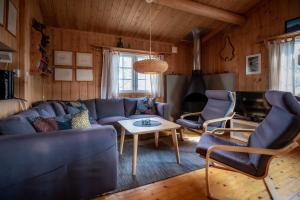 a living room with a blue couch and chairs at Trysilfjellet Nord 637 in Trysil