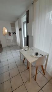 un tavolo bianco con sedie in una stanza bianca di Studio RDC l'Auron- wifi - cour a Vierzon