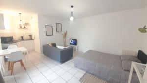 un soggiorno con un divano e un tavolo di Studio RDC l'Auron- wifi - cour a Vierzon