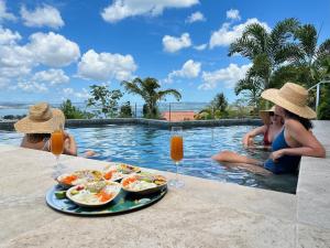 people sitting in a swimming pool with food and drinks at Villas Tangarane in Les Trois-Îlets