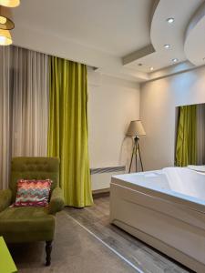 a bedroom with a large bed and a chair at Jacuzzi In Bedroom Elegance Apartments in Zlatibor +16 photos