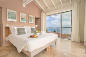 a bedroom with a bed with a view of the ocean at Villas Tangarane in Les Trois-Îlets