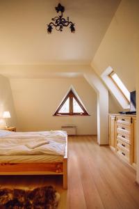 an attic bedroom with a bed and a window at Słoneczny Pacyfik in Kościelisko