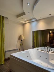 a large bath tub in a room with a large mirror at Jacuzzi In Bedroom Elegance Apartments in Zlatibor