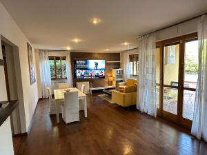 Una sala de estar con una mesa, un sofá y un televisor. en Relais Madama Dorè, en Scandicci