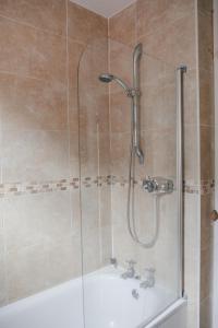 a bathroom with a shower with a tub and a sink at Victorian Terraced House in Salisbury; 3 bedrooms in Salisbury