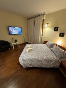 Un dormitorio con una cama y un televisor de pantalla plana. en Relais Madama Dorè, en Scandicci