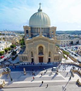 a large building with a clock tower on top of it at Happiness in Qormi
