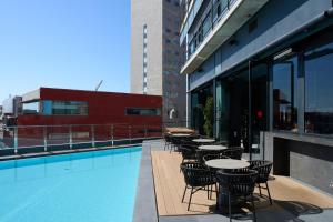 a swimming pool with tables and chairs on a building at Barcelona Princess in Barcelona