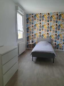 a bedroom with a bed and a wall of plates at Duplex appartement 4 chambres120m2 in Grande-Synthe