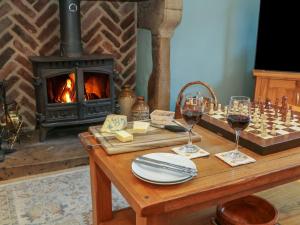 einen Tisch mit Schachbrett und Weingläsern sowie einen Kamin in der Unterkunft Buttercup Cottage in Castleton + 26 Fotos