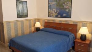 ローマにあるB&B La Bella Giulianaのベッドルーム1室(青いベッド1台、ランプ2つ付)