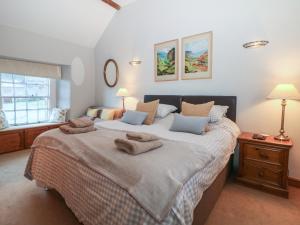 ein Schlafzimmer mit einem großen Bett mit Handtüchern darauf in der Unterkunft Buttercup Cottage in Castleton
