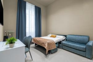 una camera ospedaliera con un letto e un divano di B&B Le Stanze del Duomo a Firenze