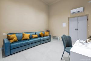 un divano blu con cuscini gialli in soggiorno di B&B Le Stanze del Duomo a Firenze