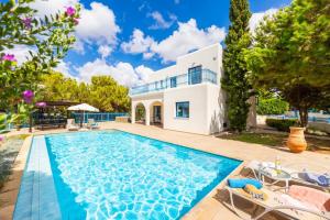 a villa with a swimming pool and a house at Azzurro Holiday Villas in Peyia
