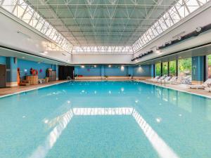 a large swimming pool in a building at Novotel Gdańsk Marina in Gdańsk