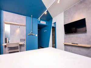 カリュイール・エ・キュイールにあるIbis Budget Lyon Caluire Cité Internationaleの青い壁のベッドルーム1室(ベッド1台付)
