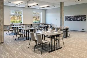 a room with tables and chairs and a white wall at Park Inn by Radisson Vilnius Airport Hotel & Conference Centre in Vilnius