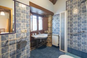 ein Badezimmer mit blau gefliesten Wänden und einem Waschbecken in der Unterkunft Casa Souto De Abajo Adaptada in Santiso + 12 Fotos