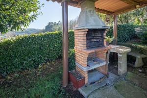 einen Backsteinofen unter einem Dach in der Unterkunft Casa Souto De Abajo Adaptada in Santiso