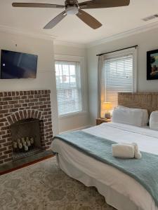 サバンナにあるHistoric Savannah Getawayの大きなベッドと暖炉のある寝室