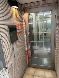 東京にあるハイクレスト中野101の建物脇の電話付き扉