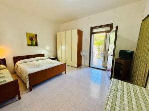 een slaapkamer met een bed en een deur naar een patio bij Asfodeli 19 in Centro in San Teodoro