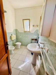 een badkamer met een wastafel en een toilet bij Asfodeli 19 in Centro in San Teodoro +21 foto's