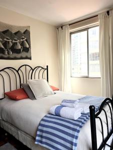 a bedroom with a bed with a blue and white blanket at Departamento soleado y acogedor en el mejor barrio de la ciudad in La Paz