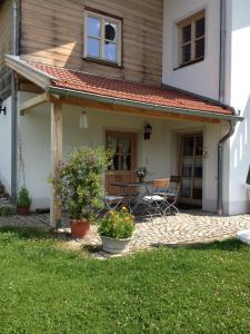 a small white house with a patio at Ferienwohnung Familie Kitzke in Teisnach