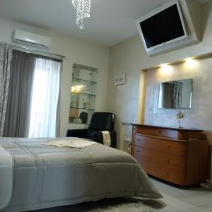 a bedroom with a bed and a chair and a television at Luxury 9 person Holiday Home a walk to Paceville's nightlife in Is-Swieqi