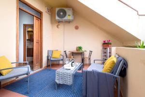 een balkon met stoelen, een tafel en een ventilator bij Villa Le Dune a few steps from the sandy beach of Maria Pia in Alghero