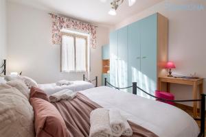 een slaapkamer met 2 witte bedden en een raam bij Villa Le Dune a few steps from the sandy beach of Maria Pia in Alghero