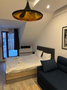 a bedroom with a bed and a couch at Kopaonik Apartmani Milmari - Katic in Kopaonik