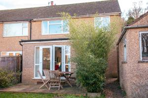 a patio with a table and chairs in front of a house at Entire 3 bedroom house, SALISBURY Cathedral City in Salisbury