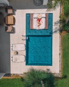 a teddy bear sitting on a bed next to a pool at TAF Beach Villas with TESLA in Tigaki